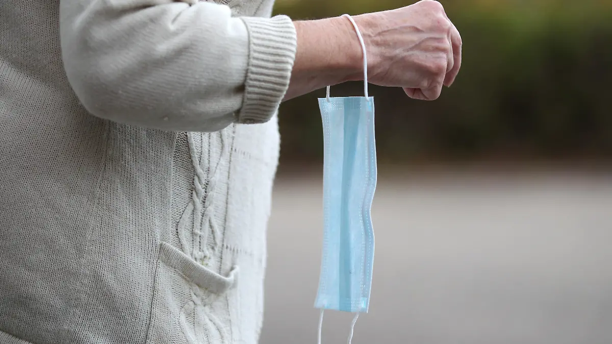 Themenbild - Rentnerin, Seniorin schuetzt sich mit einer Einwegmaske vor dem Coronavirus Bild: Model release, Model relased, eine aeltere Frau, Rentnerin, Seniorin schuetzt sich mit der blauen Einwegmaske, Mundschutz, Coronamaske vor dem Coronavirus Symbolbild, Themenbild, Featurebild
