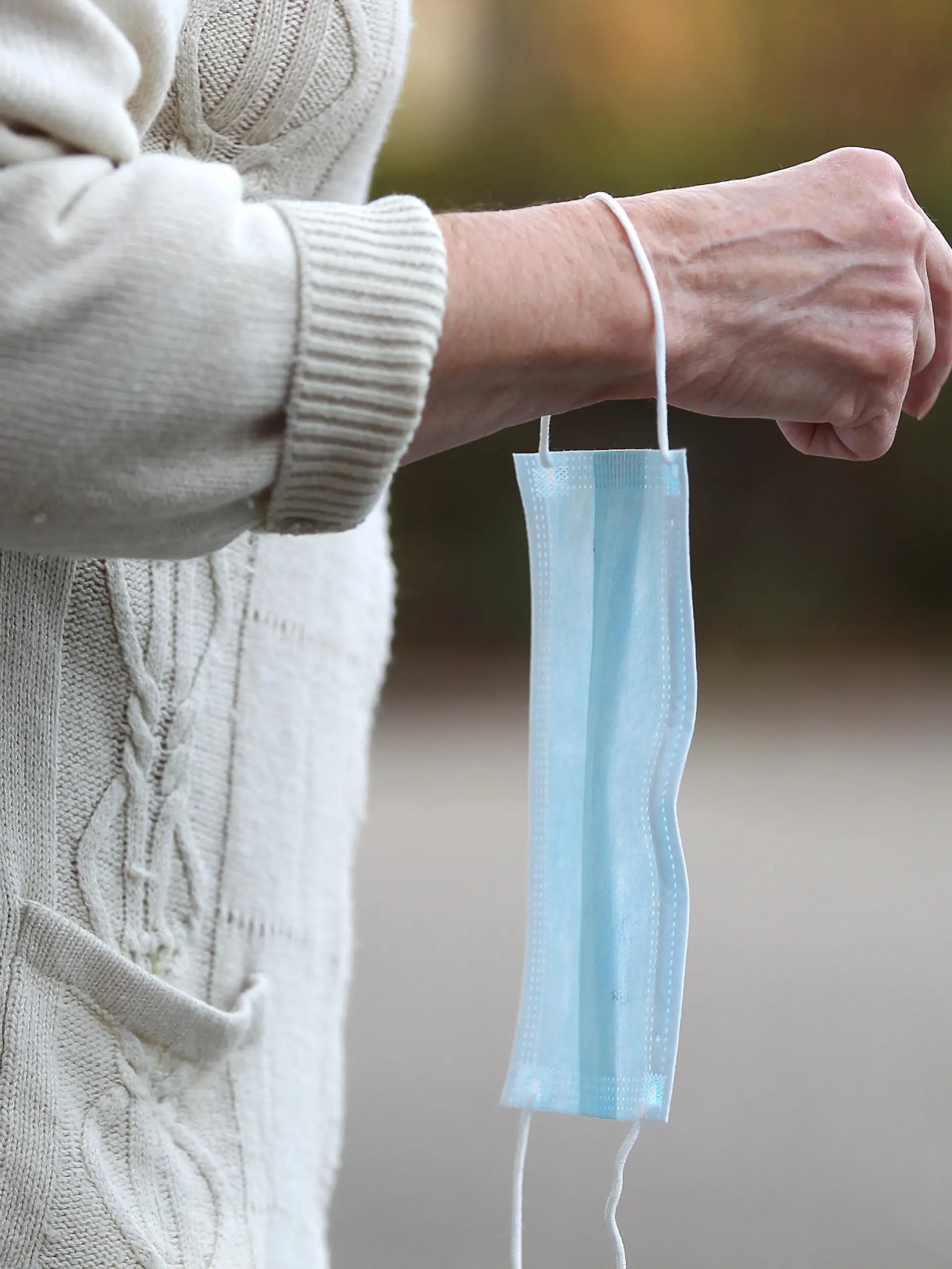 Themenbild - Rentnerin, Seniorin schuetzt sich mit einer Einwegmaske vor dem Coronavirus Bild: Model release, Model relased, eine aeltere Frau, Rentnerin, Seniorin schuetzt sich mit der blauen Einwegmaske, Mundschutz, Coronamaske vor dem Coronavirus Symbolbild, Themenbild, Featurebild