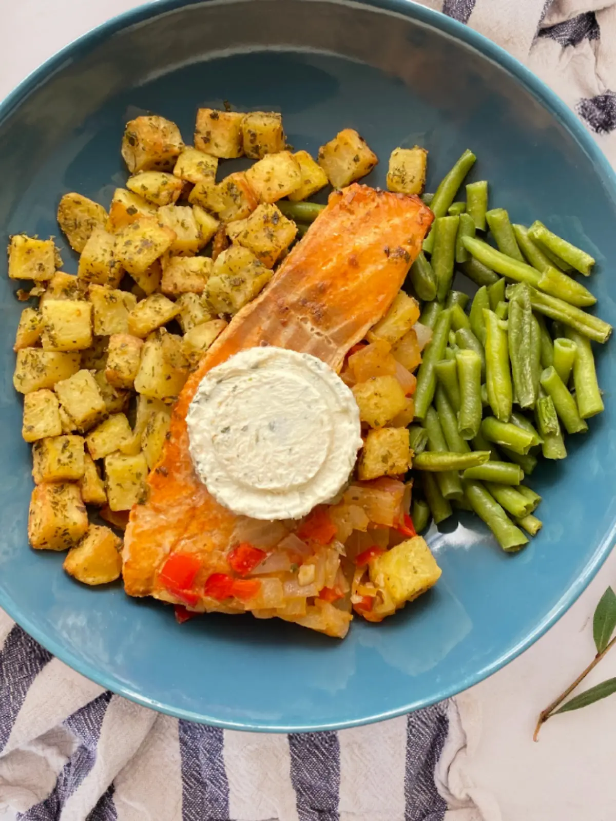 Factor Gericht aus Lachs mit Joghurtsauce, Bohnen und Kartoffeln auf einem Teller