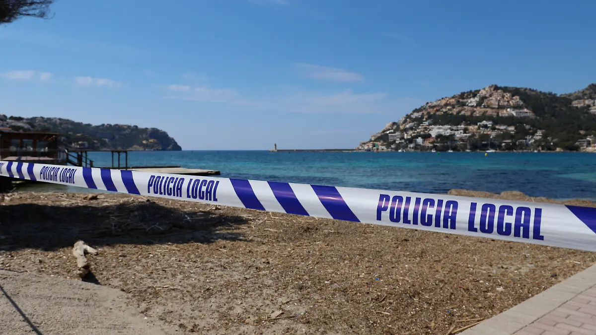 ARCHIV - 10.04.2020, Spanien, Port Andratx: Mit einem Absperrband der Polizei ist der Zugang zu einem Strand auf der Insel Mallorca abgesperrt. (zu dpa «Spaniens Regierung: Tourismus wohl erst gegen Jahresende wieder aktiv») Foto: Clara Margais/dpa +++ dpa-Bildfunk +++