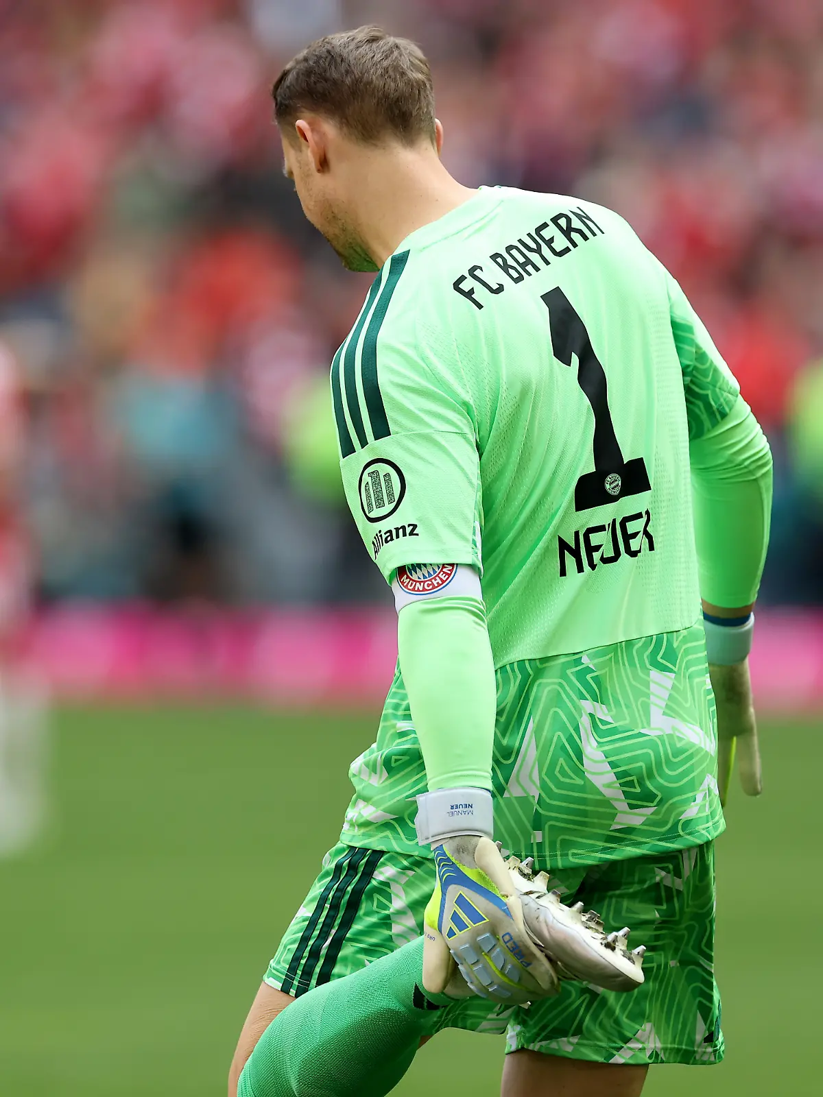Manuel Neuer im Shirt von FC Bayern München hält seinen Fuß
