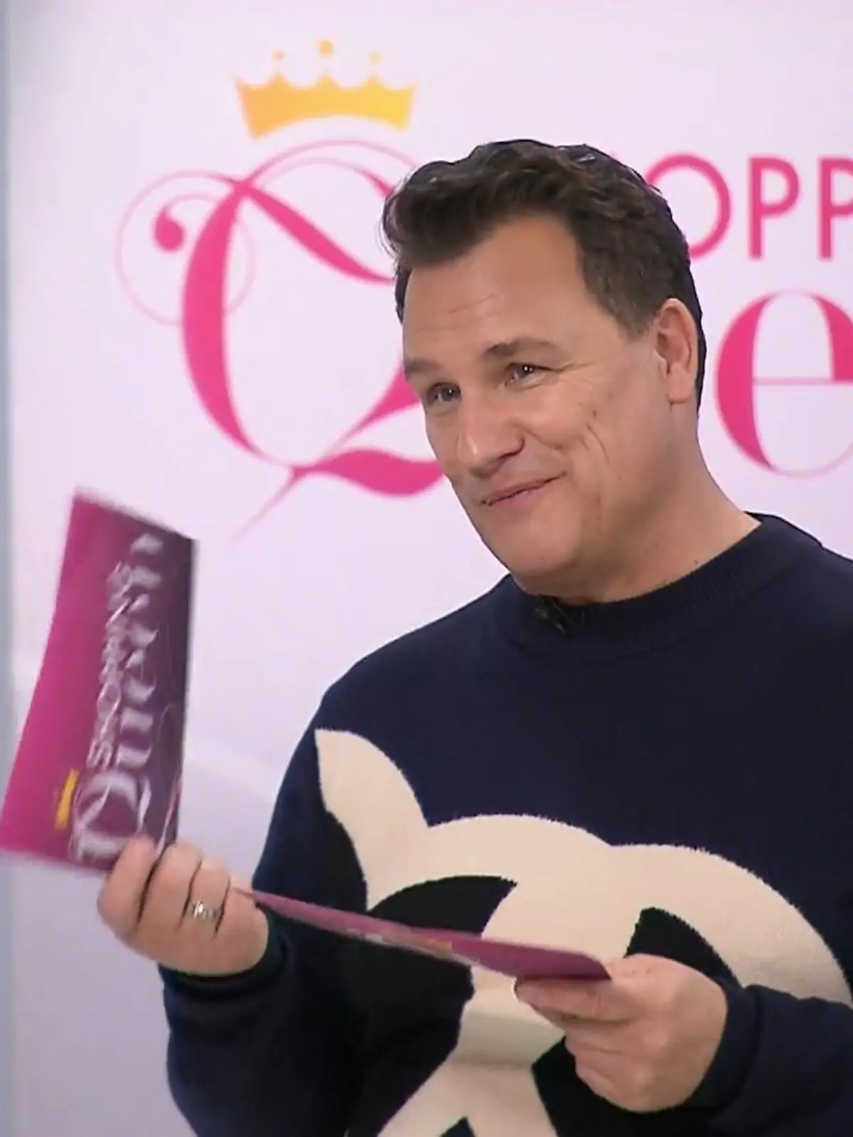 Guido hält auf dem Catwalk seine Moderationskarten in den Händen.