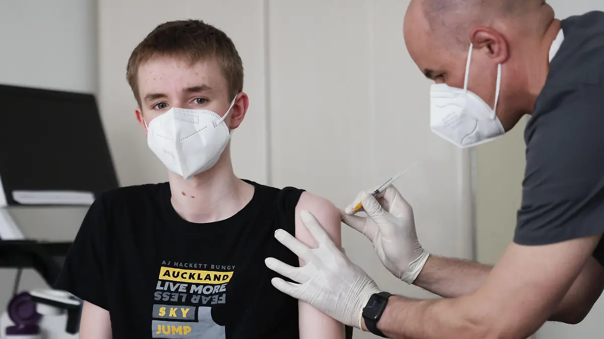 02.06.2021, Nordrhein-Westfalen, Köln: Jan Wolters (15) wird in einer Arztpraxis von dem Hausarzt Tim Koop (r) mit dem Serum von Biontech/Pfizer geimpft. Hausärzte haben begonnen, Kinder und Jugendliche gegen das Coronavirus zu impfen. Foto: Oliver Berg/dpa +++ dpa-Bildfunk +++