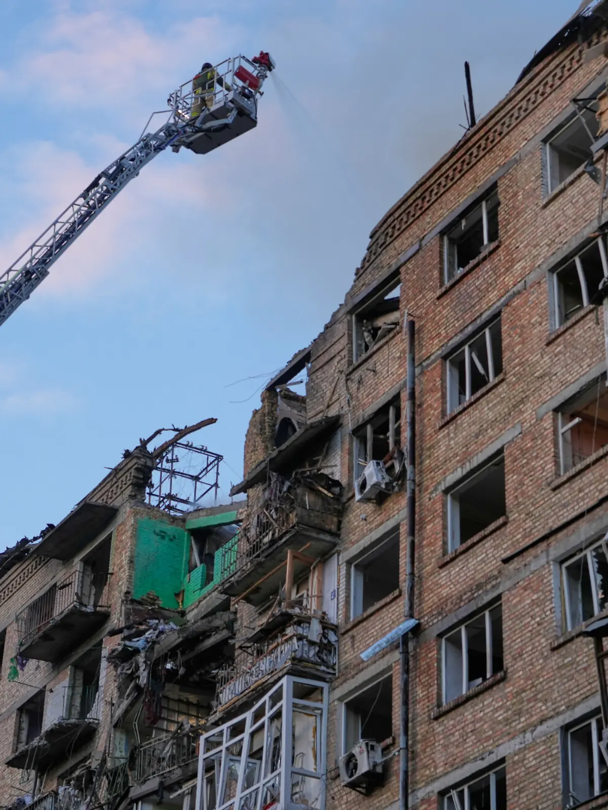 Feuerwehrleute arbeiten an einem brennenden Gebäude nach einem russischen Raketenangriff. +++ dpa-Bildfunk +++