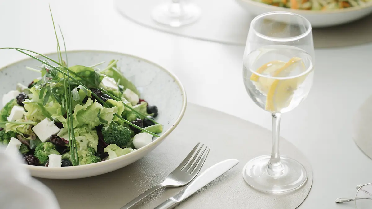 Salad and glass of water on a table in a restaurant PUBLICATIONxINxGERxSUIxAUTxHUNxONLY AHSF00358  