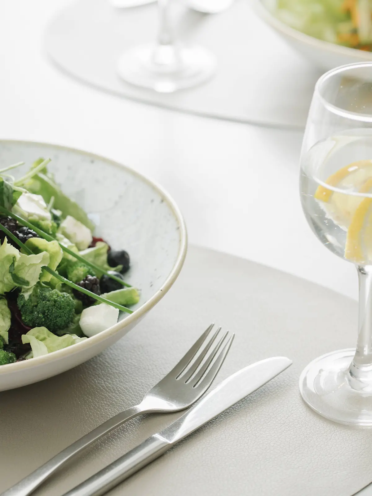 Salad and glass of water on a table in a restaurant PUBLICATIONxINxGERxSUIxAUTxHUNxONLY AHSF00358