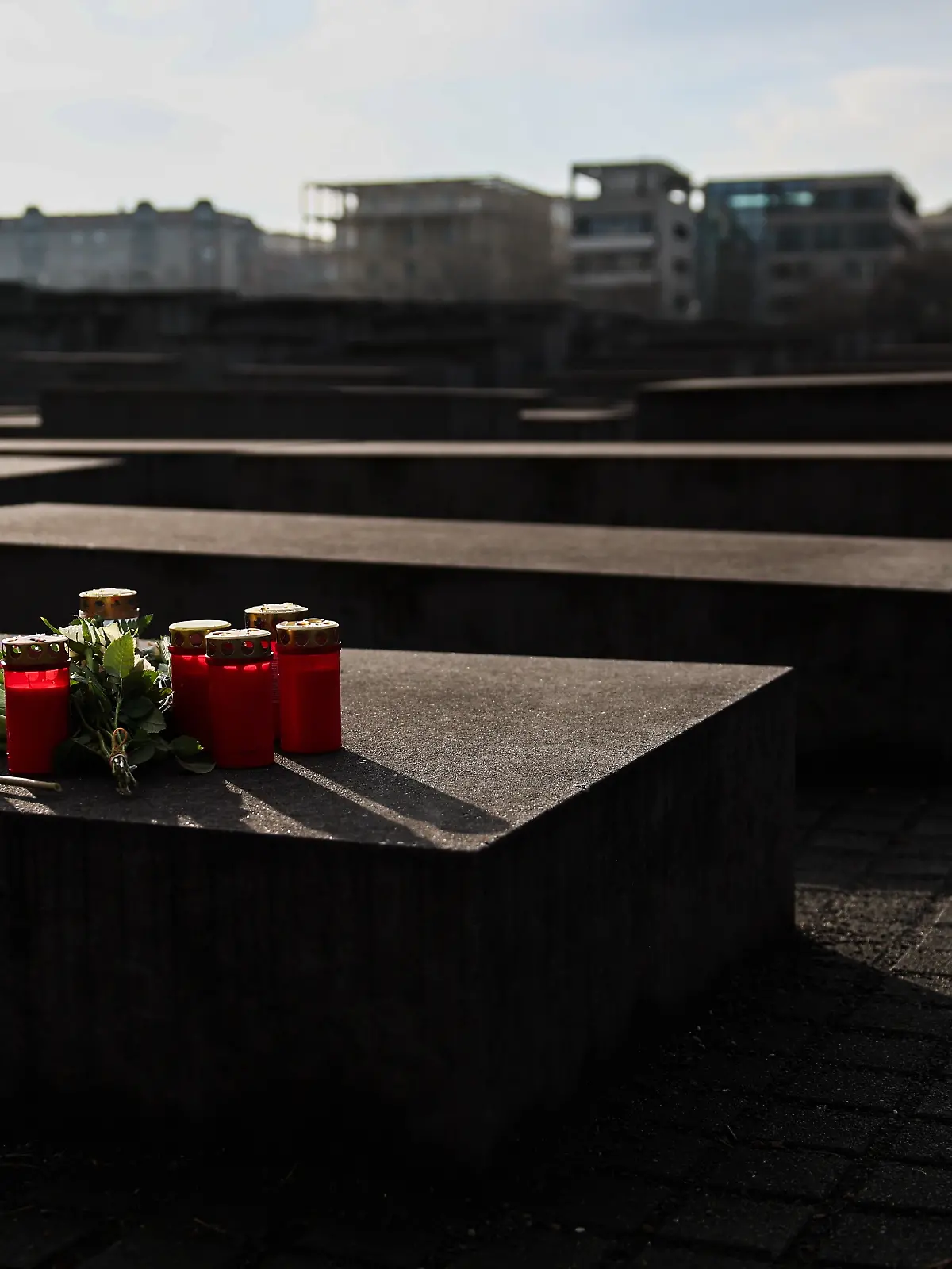 Blumen und Kerzen wurden auf einer Stehle am Denkmal für die ermordeten Juden Europas niedergelegt. (zu dpa: «Neuer Verdächtiger nach Messerangriff am Holocaust-Mahnmal») +++ dpa-Bildfunk +++