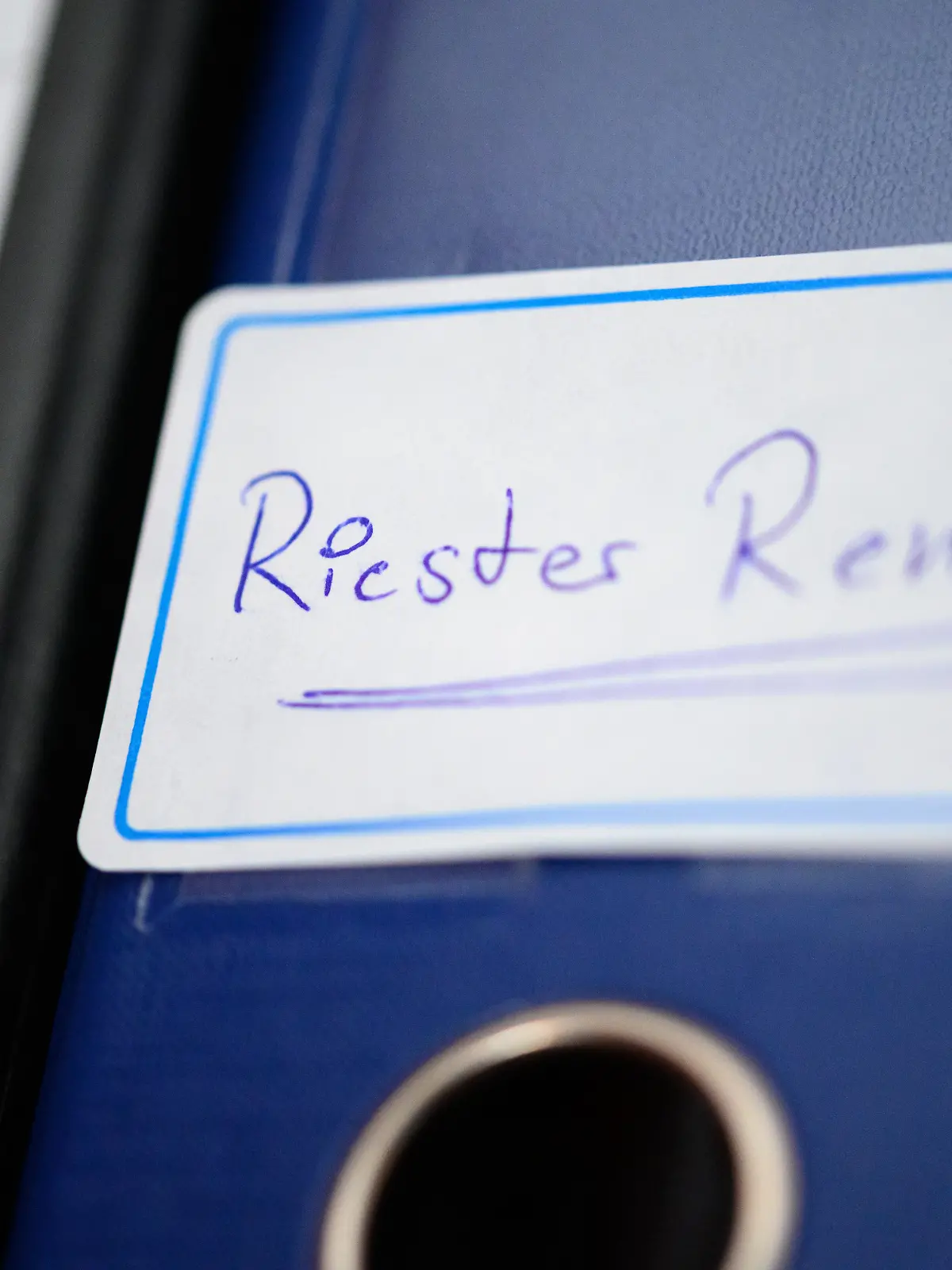 Ein Ordner mit einem Aufkleber "Riester-Rente" steht in einem Regal.