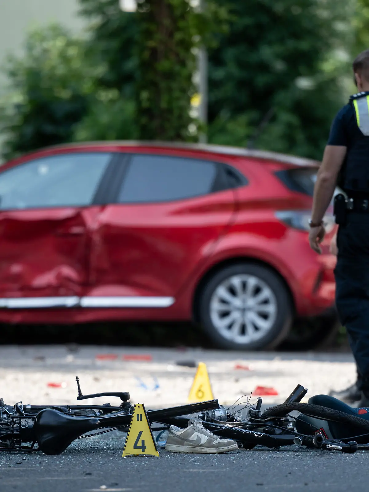 27.05.2026, Nordrhein-Westfalen, Dinslaken: Ein Fahrrad liegt auf der Straße. Die Polizei sichert eine Unfallstelle, nachdem eine Autofahrerin drei Kinder vor einer Schule in Dinslaken verletzt hat. Foto: Fabian Strauch/dpa +++ dpa-Bildfunk +++