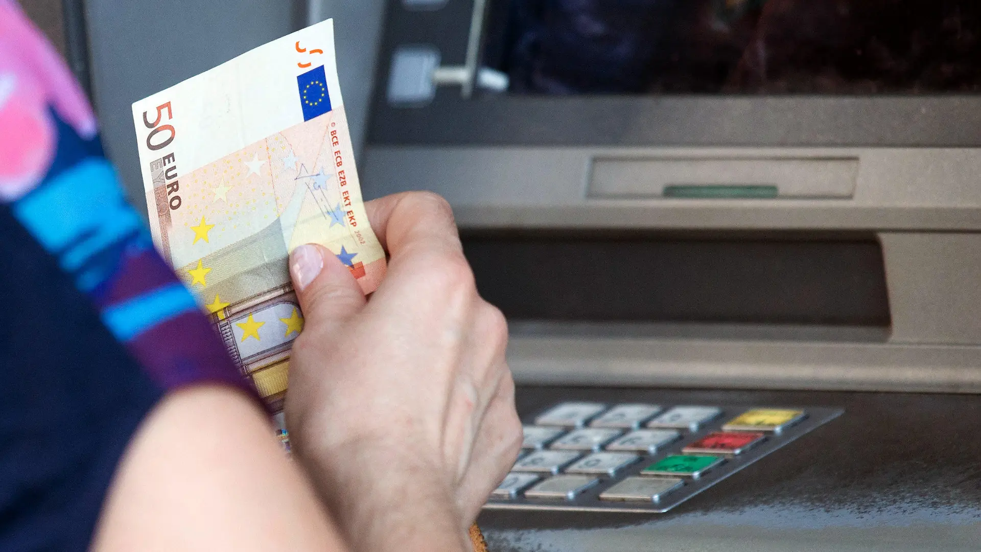 A woman withdraws 50 Euro from an ATM in central Athens, Greece, 06 July 2015. The Greek finance minister has resigned following Sunday's referendum in which the majority of voters said 'no' to more austerity measures in exchange for another financial bailout. Photo: Kay Nietfeld/dpa +++(c) dpa - Bildfunk+++