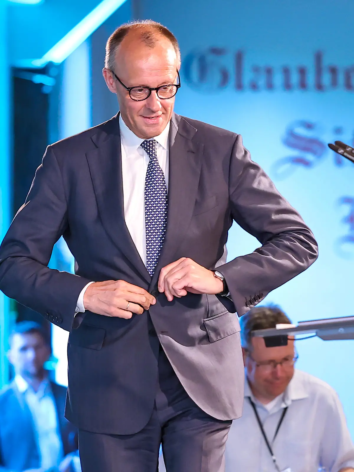 27.05.2026, Politik, Bundeskanzler Friedrich Merz (CDU) betritt die Bühne für seine Rede zu Gast als Festredner beim Festakt in der Schützenhalle Hüsten bei Arnsberg. 80 Jahre Neheim-Hüstener Programm.