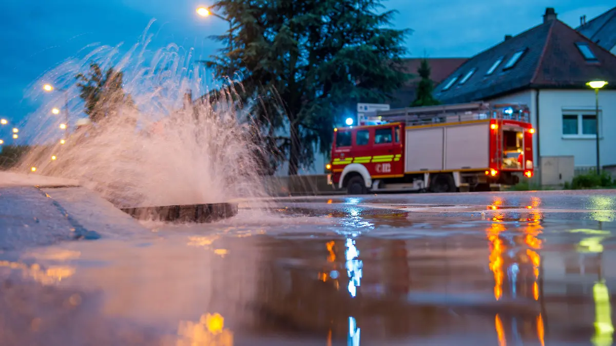 Wasser dringt am 26.05.2014 in Freising (Bayern) aus einem Gulli. Die Feuerwehr im Landkreis Freising wurde zu zahlreichen Unwettereinsätzen gerufen. Foto: Marc Müller/dpa +++(c) dpa - Bildfunk+++
