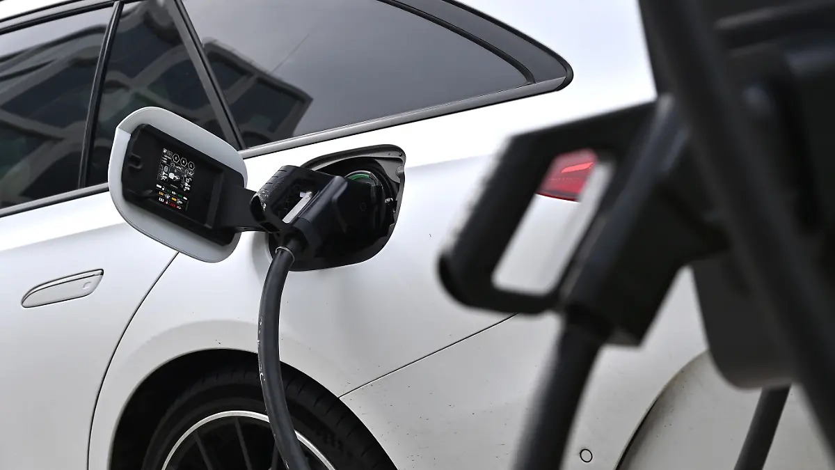 Stromtankstelle, E-Auto wird auf einem Parkplatz fuer Elektro-Fahrzeuge geladen,Stecker waehrend dem Ladevorgang an einem E-Auto,E-Autos, Elektroauto,Ladestecker,Ladekabel, Ladesaeule,Ladebuchse,Ladevorgang, E-Mobilitaet,Elektrifizierung. Elektromobilitaet,Stecker. Autobauer,Auto,Autos,Automobile, Hersteller,Autoindustrie, Elektrofahrzeug,Elektrofahrzeuge.Ladestation.