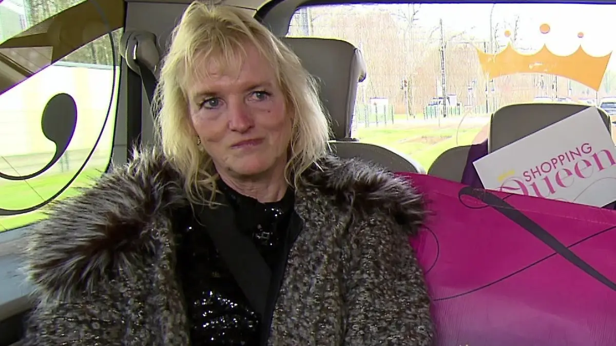 Sabine sitzt auf der Rückbank, neben ihr eine Shopping-Queen-Tasche
