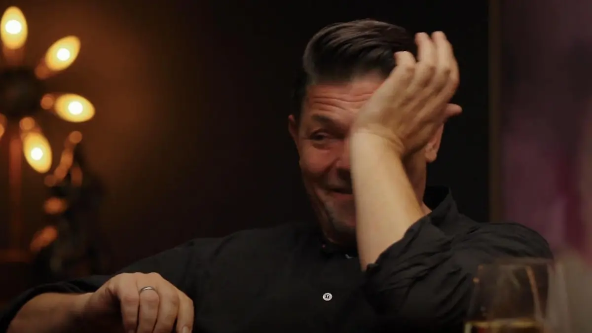 Tim Mälzer reibt sich mit dem Handballen sein tränendes Auge.