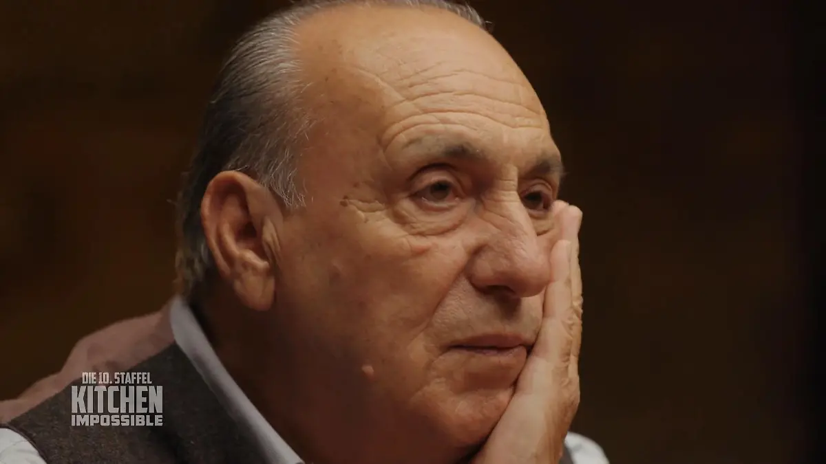Gennaro blickt nachdenklich, seine Hand hält sein Gesicht. 