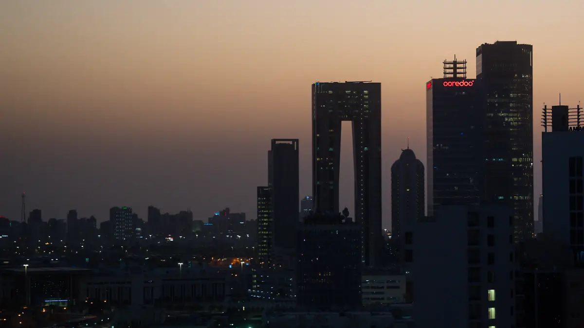 Die aufgehende Sonne färbt den Himmel hinter der Skyline von Kuwait-City rötlich. (zu dpa: «Kuwait meldet feindliche Angriffe mit Raketen und Drohnen») +++ dpa-Bildfunk +++