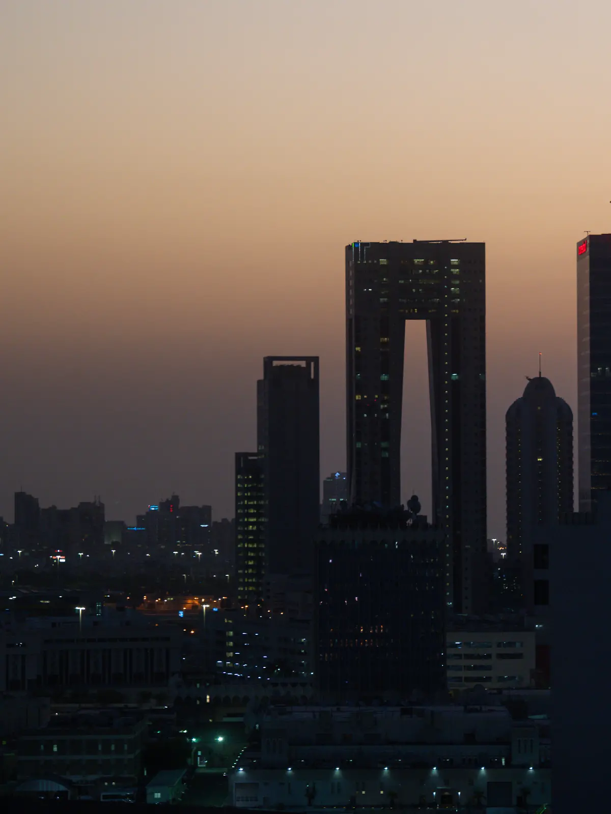 Die aufgehende Sonne färbt den Himmel hinter der Skyline von Kuwait-City rötlich. (zu dpa: «Kuwait meldet feindliche Angriffe mit Raketen und Drohnen») +++ dpa-Bildfunk +++