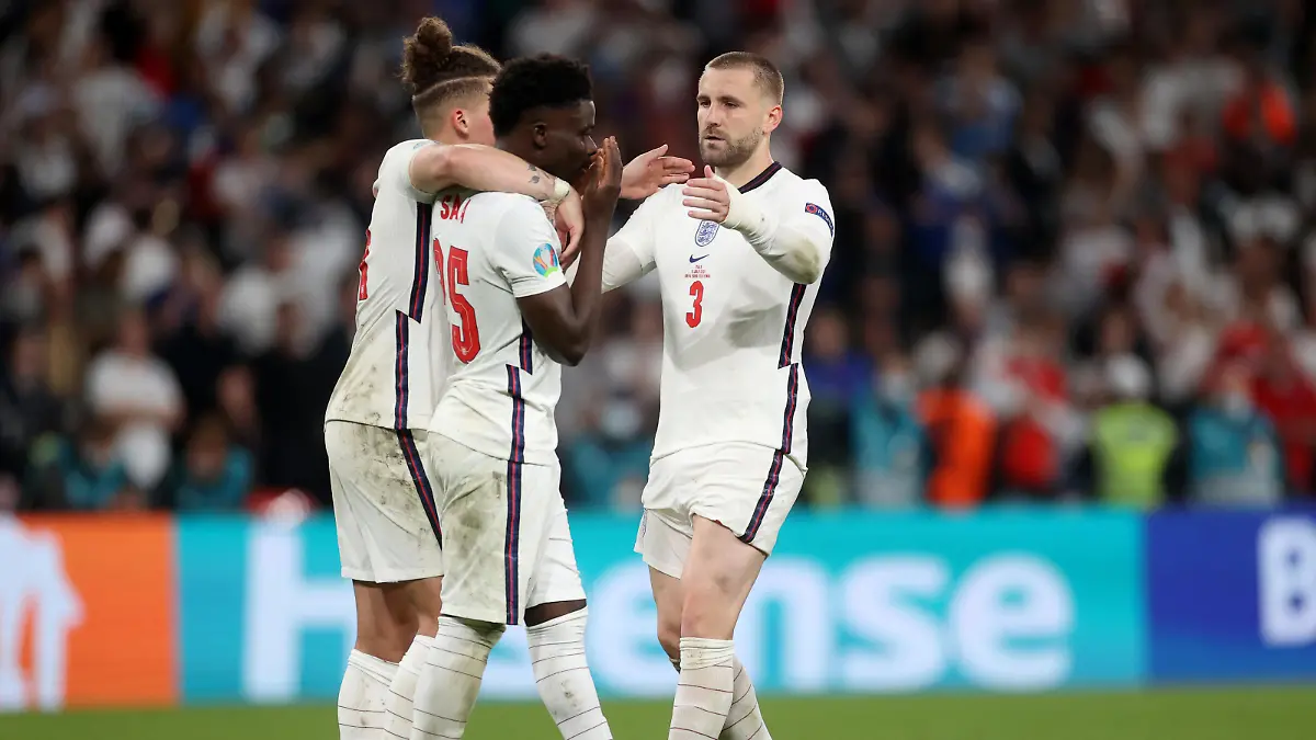 LONDON, ENGLAND - JULY 11: Bukayo Saka of England is consoled by teammates Kalvin Phillips and Luke Shaw after having their team's fifth penalty saved in a penalty shoot out during the UEFA Euro 2020 Championship Final between Italy and England at Wembley Stadium on July 11, 2021 in London, England. (Photo by Carl Recine - Pool/Getty Images)