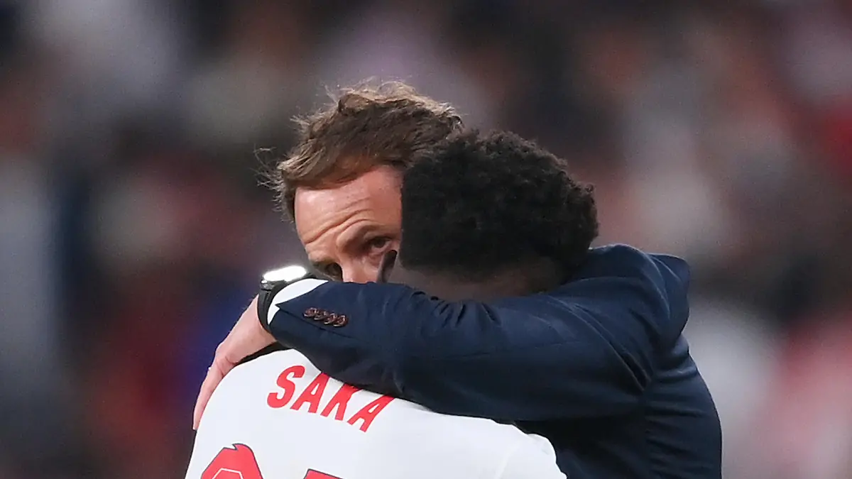 LONDON, ENGLAND - JULY 11: Bukayo Saka of England is consoled by Gareth Southgate, Head Coach of England following defeat in the UEFA Euro 2020 Championship Final between Italy and England at Wembley Stadium on July 11, 2021 in London, England. (Photo by Laurence Griffiths/Getty Images)
