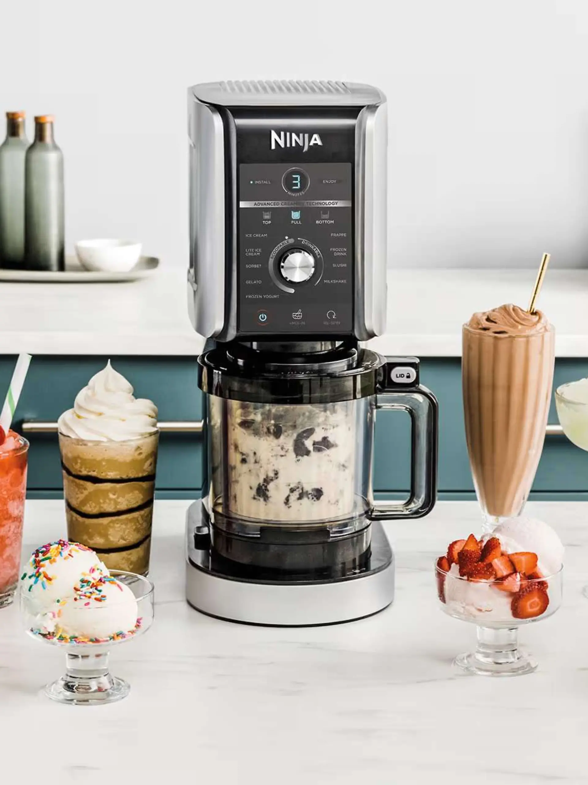 Ninja Creami Eismaschine auf einer Küchenarbeitsfläche, daneben Eiskreationen.