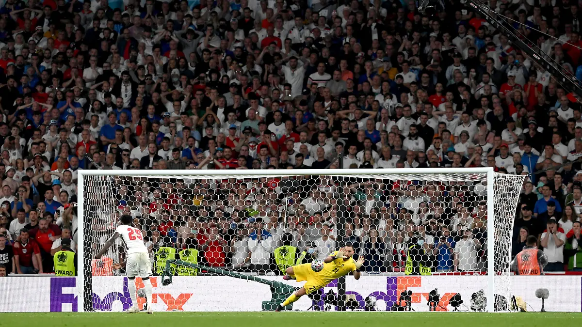 LONDON, ENGLAND - JULY 11: Bukayo Saka of England misses his team's fifth penalty in a penalty shoot out which is saved by Gianluigi Donnarumma of Italy during the penalty shoot out in the UEFA Euro 2020 Championship Final between Italy and England at Wembley Stadium on July 11, 2021 in London, England. (Photo by Paul Ellis - Pool/Getty Images)