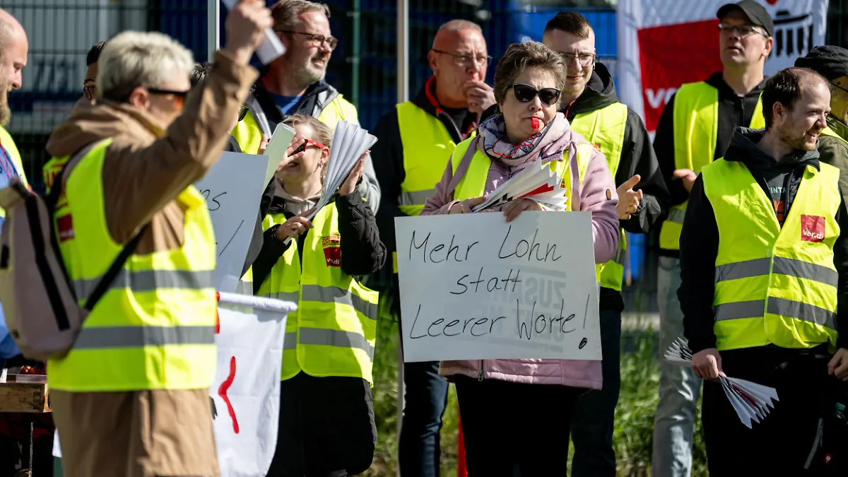 Lagerarbeiter nehmen am Verdi-Warnstreik im Großhandel in Berlin und Brandenburg neben dem PENNY Logistikzentrum Ost Großbeeren mit einem Schild mit der Aufschrift „Mehr Lohn statt leere Worte!“ teil.