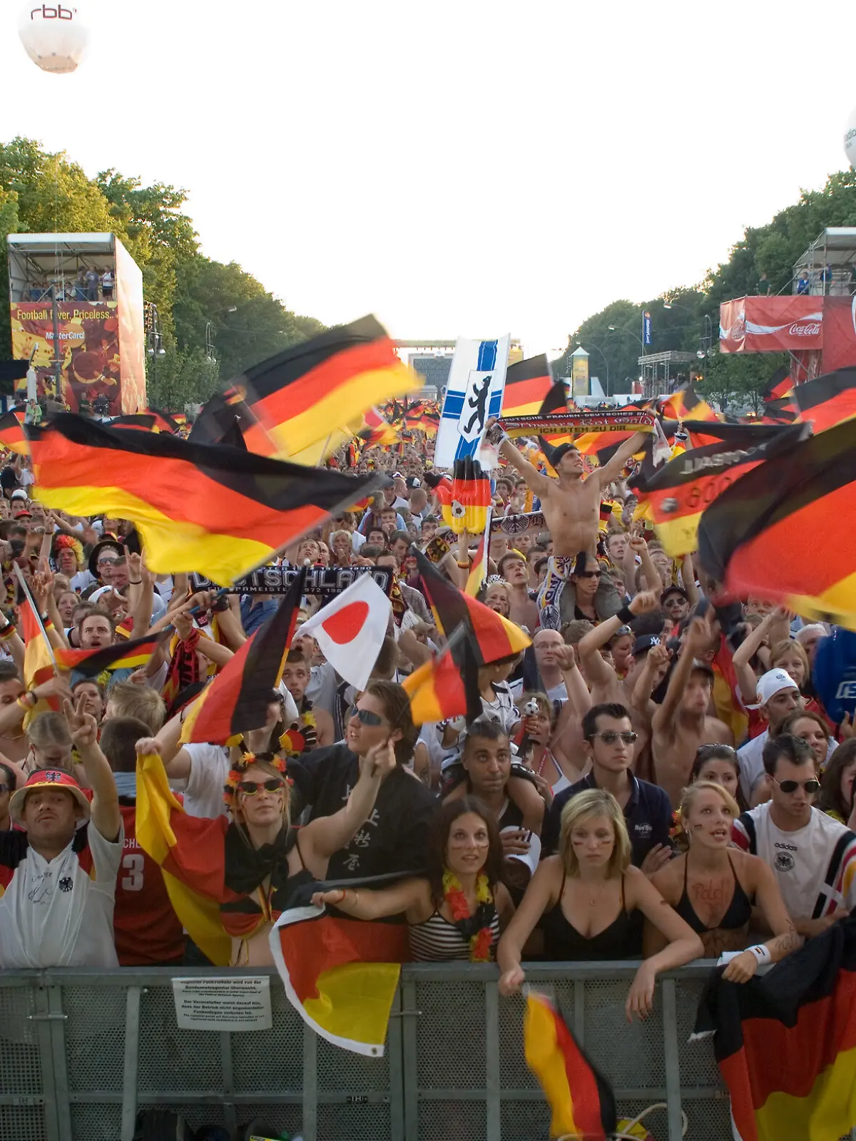 04.07.2006, Berlin, Deutschlandeuphorie zur FIFA-WM 2006 - Deutsche Fans zeigen Gefuehle und Nationalstolz waehrend der WM in einem bisher nie dagewesenen Ausmass. Hier auf der Berliner Fanmeile waehrend des Spiels Deutschland - Italien. (Symbol, Mensch, Menschen, WM-Stimmung, Patriotismus, patriotisch, Nationalismus, Stolz, Nationalstolz, Fanatismus, Deutschlandgefuehl, Deutschlandfahne, Deutschlandflagge, Schwarzrotgold, Schwarz-Rot-Gold, Schwarz, Rot, Gold, Fussball, Public Viewing, Fans, Fussballfans, Fussballfan, Symbolbild, symbolisch, Fanmeile, Fanfest, Fan, Sport, Begeisterung, Emotion, Emotionen, Enthusiasmus, Euphorie, Freizeit, Freude, Spass, Stimmung, Gesellschaft, Menschenmenge, Menschenmasse, Deutsch, Deutschland, Europa, FIFA World Cup 2006, Fussball Weltmeisterschaft 2006, Fussball WM, Fussballweltmeisterschaft, digital, QF, Gefühle, Deutschlandgefühl) 00M060704D018CARO.JPG