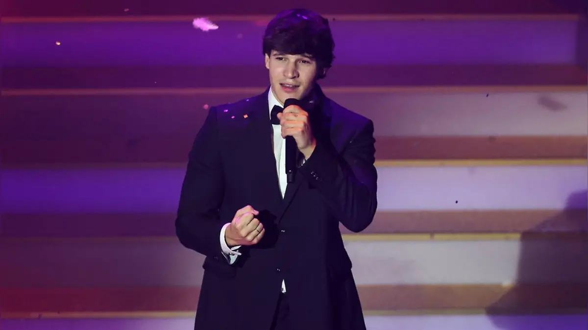 Wincent Weiss singend, in einem schwarzen Anzug, mit einem Mikro in der Hand