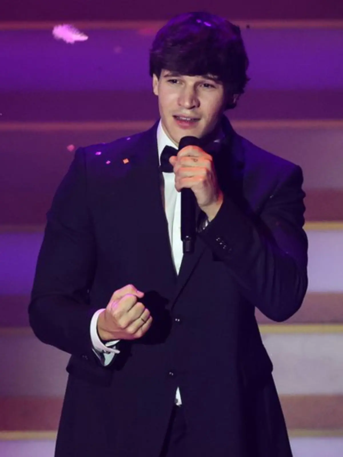 Wincent Weiss singend, in einem schwarzen Anzug, mit einem Mikro in der Hand