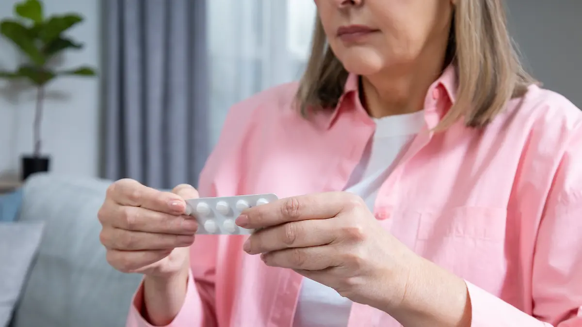 Frau mittleren Alters nimmt Tabletten.
