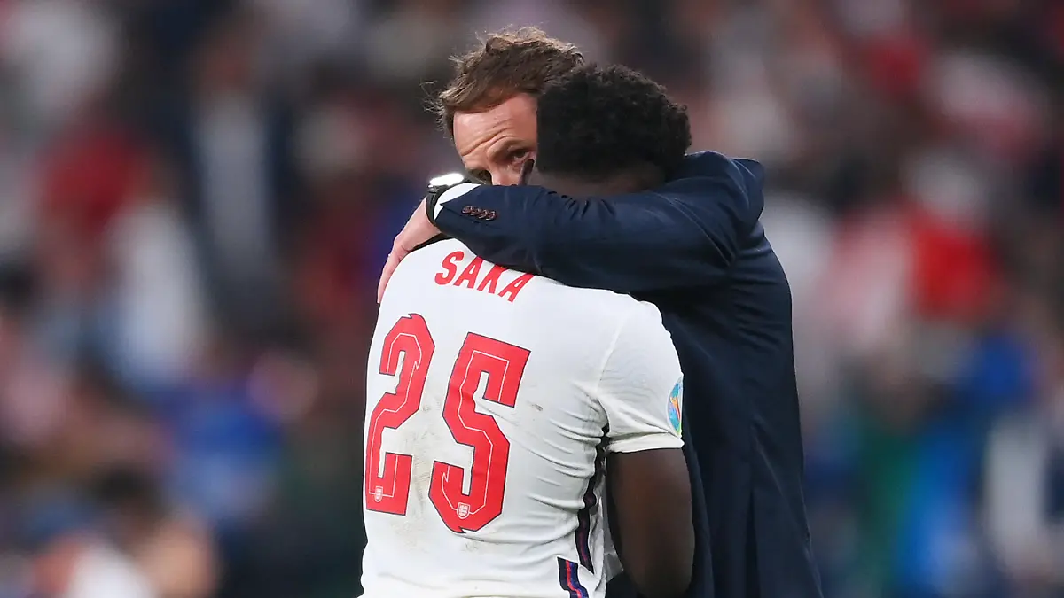 LONDON, ENGLAND - JULY 11: Bukayo Saka of England is consoled by Gareth Southgate, Head Coach of England following defeat in the UEFA Euro 2020 Championship Final between Italy and England at Wembley Stadium on July 11, 2021 in London, England. (Photo by Laurence Griffiths/Getty Images)