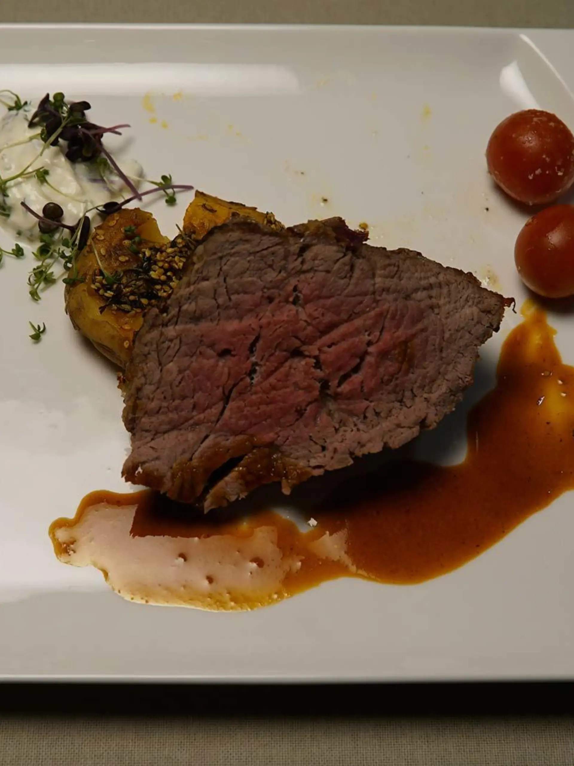 Wagyu-Filet mit leichter Kruste, Jus, gratinierten Tomaten und Smashed Potatoes mit frischem Dip