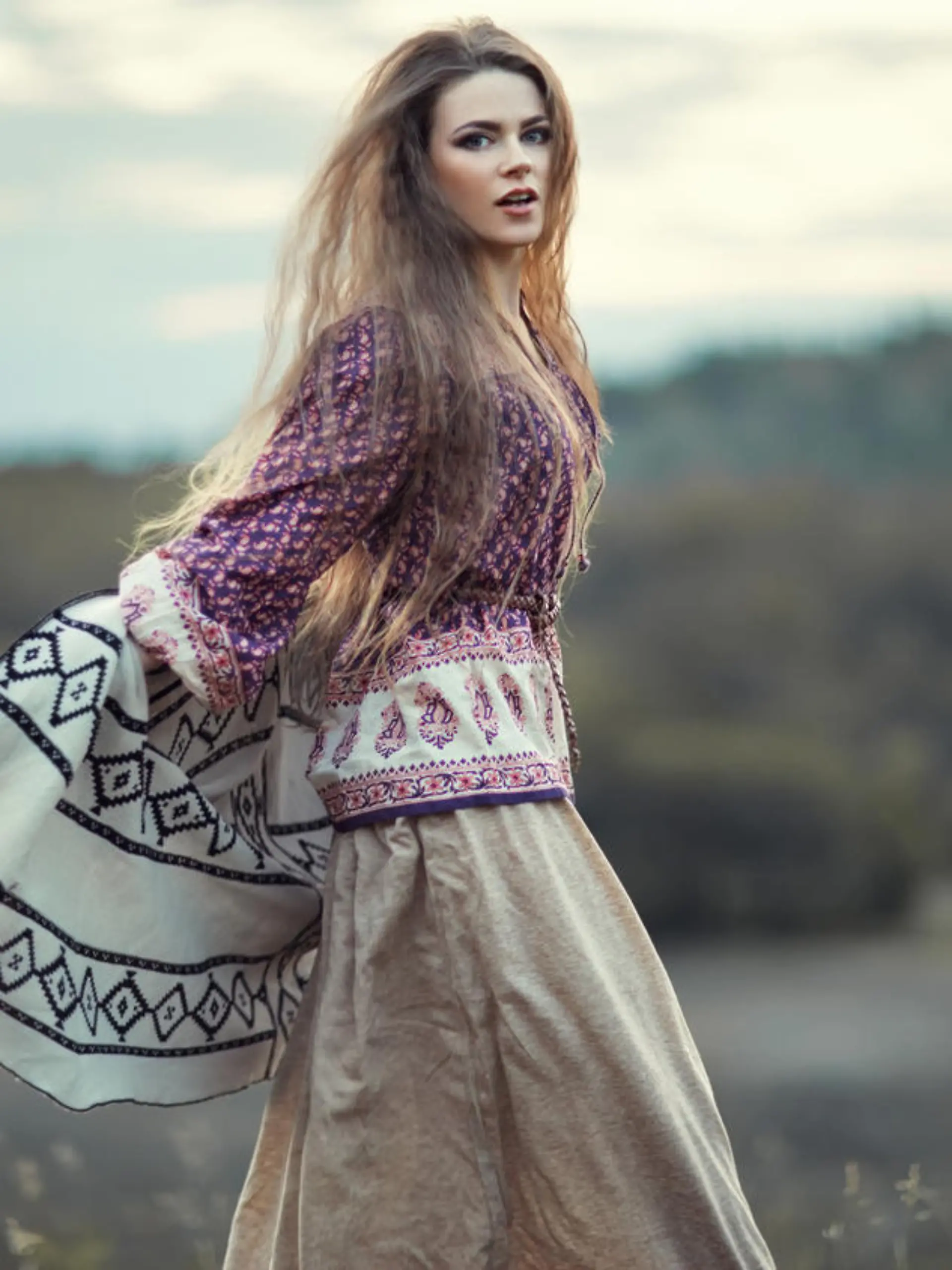 Beautiful hippie girl jumping outdoors at sunset. Boho fashion style