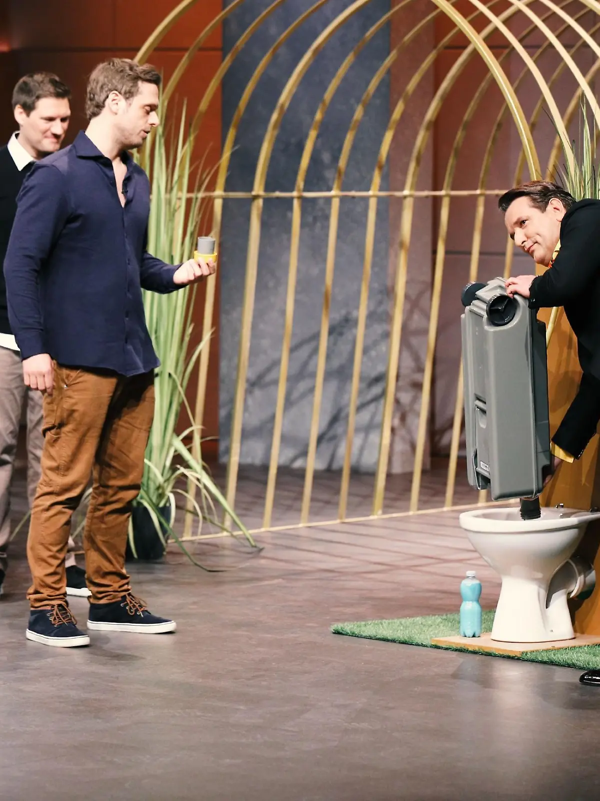 Dr. Simon Freutel (M.) und Ralf Winkelmann (l.) aus Düsseldorf präsentieren mit "Camping Butler" einen Vollautomaten zur Reinigung von Camping-Toiletten-Kassetten. Investor Ralf Dümmel nimmt das Produkt genau unter die Lupe.