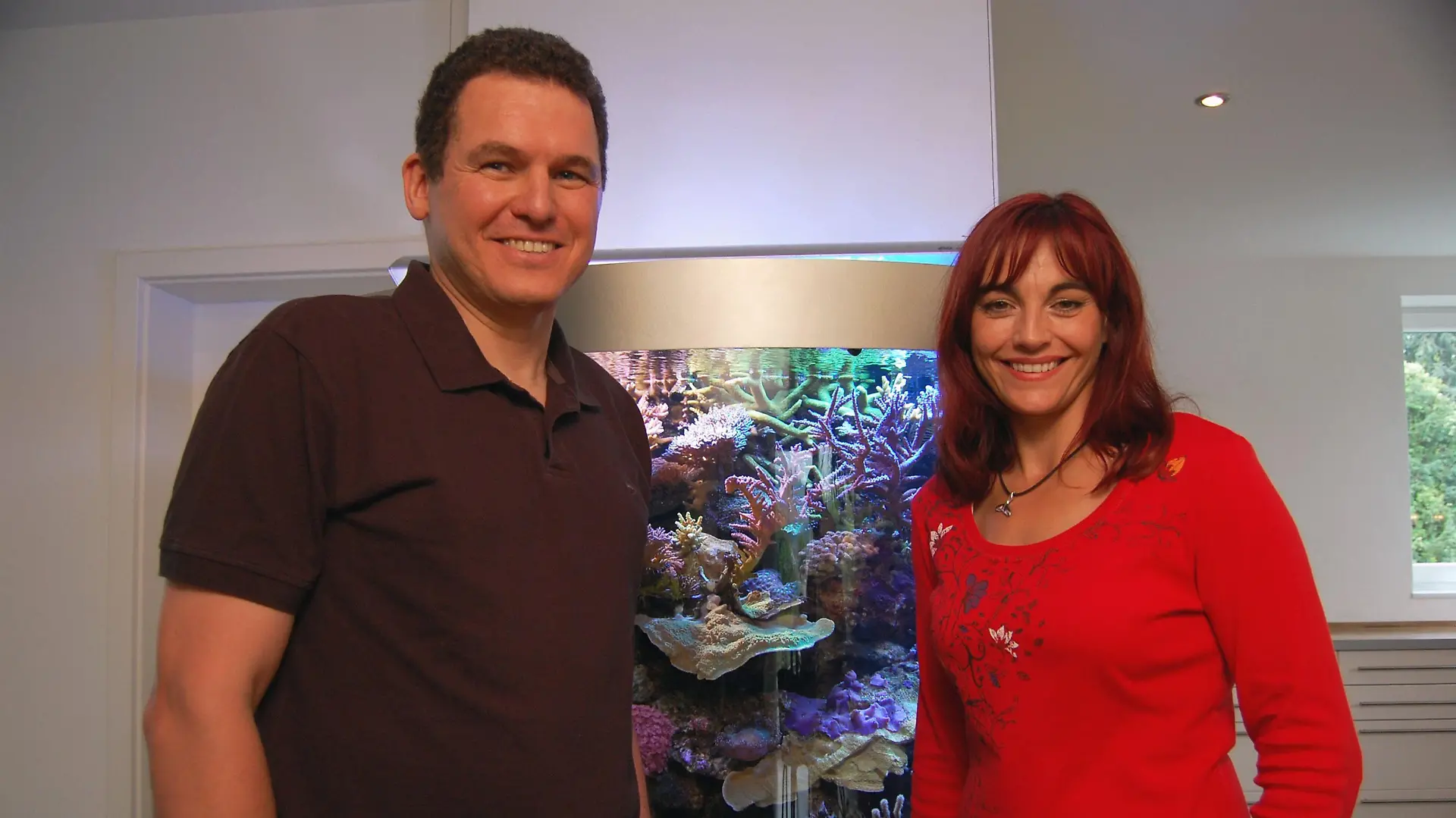 Jürgen Kutzer und Moderatorin vor einem Korallenaquarium.