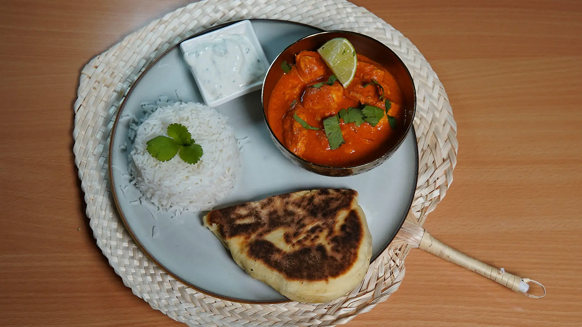 Indisches Butter-Chicken mit Reis, Naan-Brot und Gurken-Minz-Raita