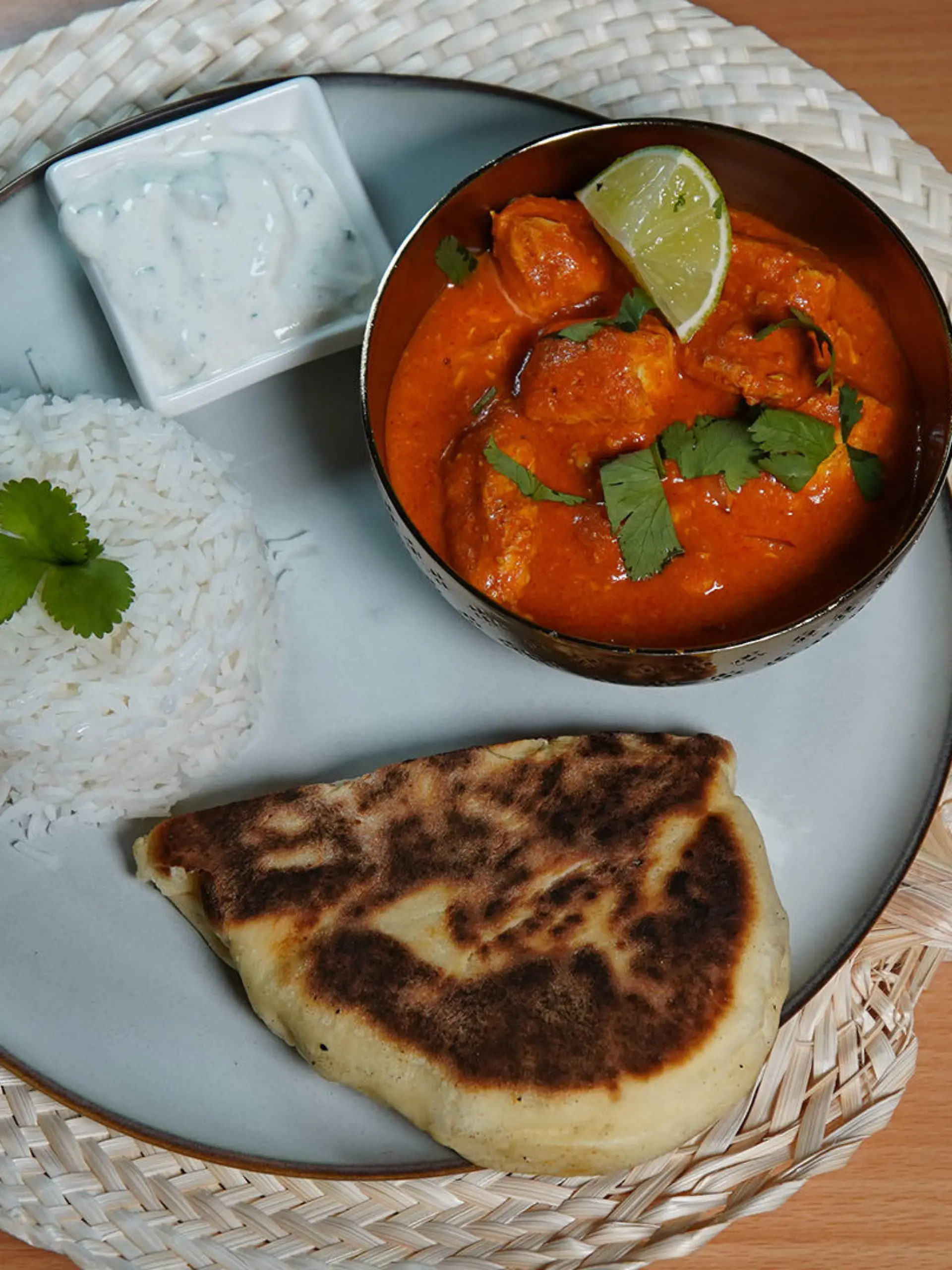Indisches Butter-Chicken mit Reis, Naan-Brot und Gurken-Minz-Raita