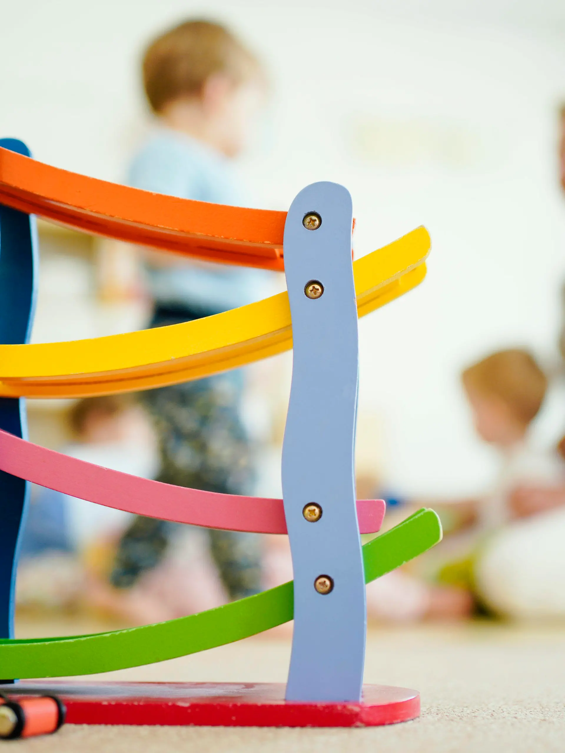 ARCHIV - 29.06.2020, Baden-Württemberg, Schriesheim: Eine Erzieherin spielt in einer Kindertagesstätte hinter einer Rollbahn mit Kindern. (zu dpa «Umfrage: Überlastung bei Kita-Personal, Unterforderung bei Kindern») Foto: Uwe Anspach/dpa +++ dpa-Bildfunk +++