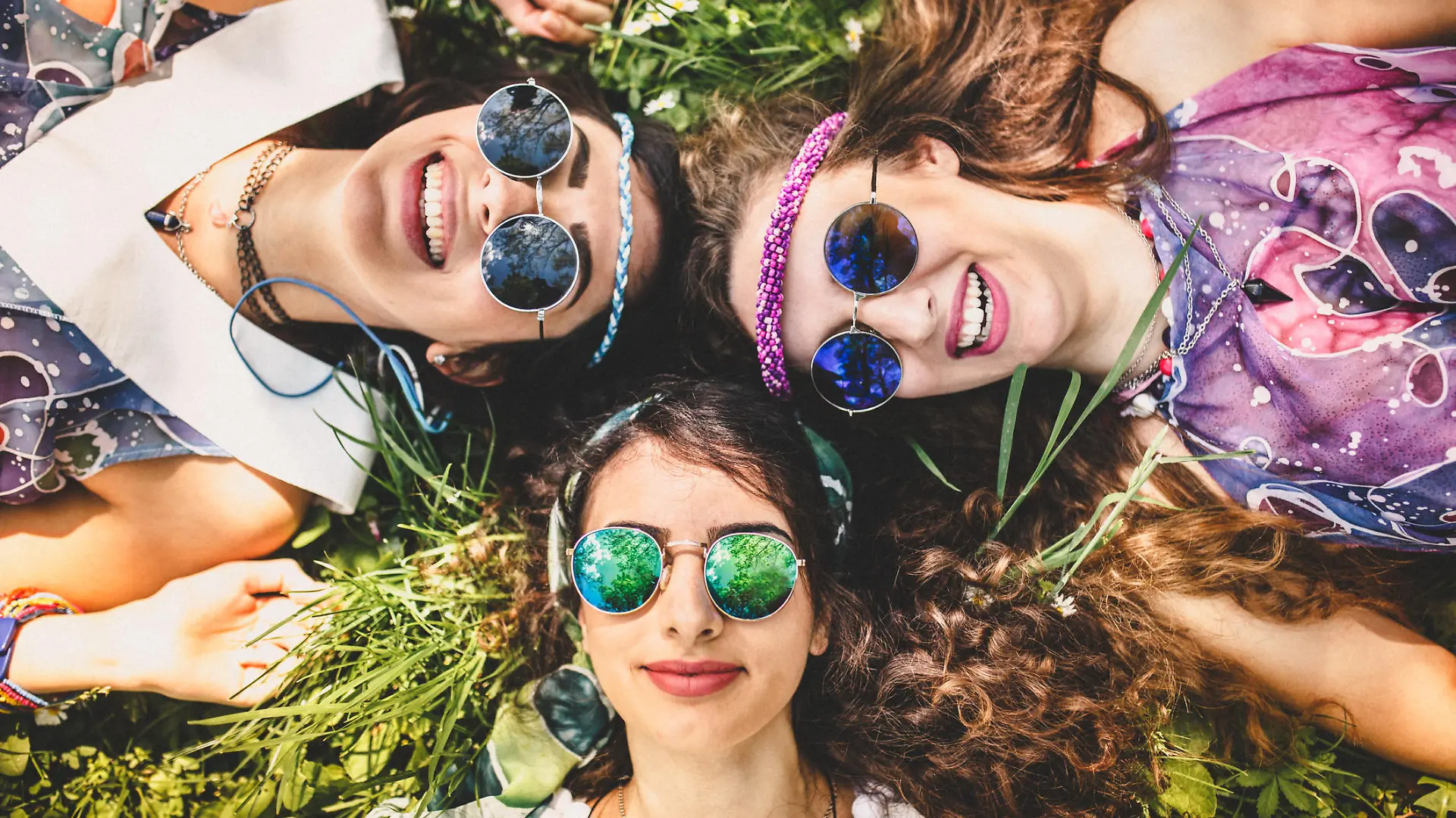 Beautiful girls of hippie laying on the grass and daisy flowers