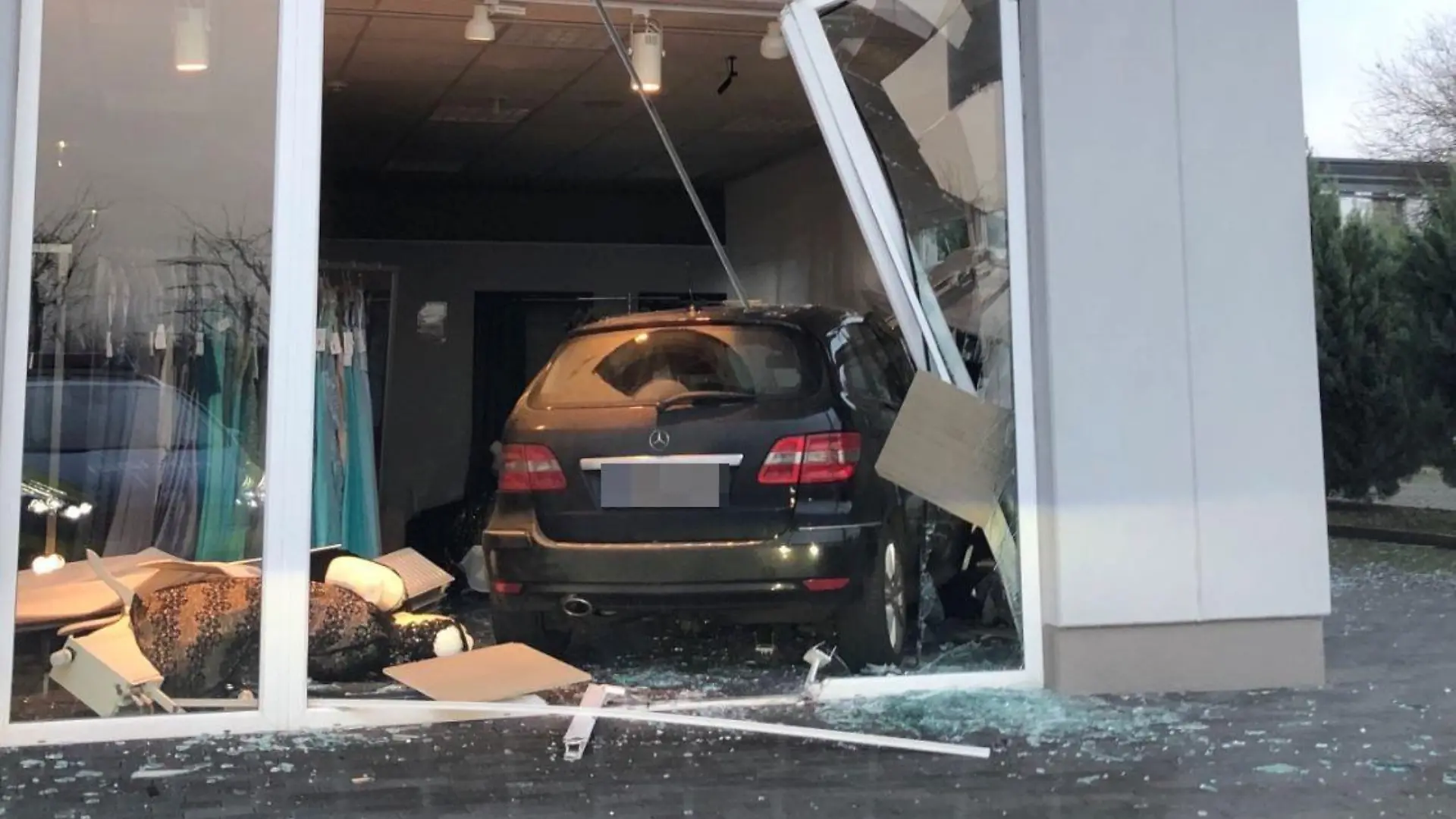 HANDOUT - 27.01.2022, Kerpen: Nach einem missglückten Einparkmanöver ist ein Auto in Kerpen erst im Verkaufsraum eines Brautmodengeschäfts zum Stehen gekommen. Verletzt wurde niemand. (Zu dpa: «Eingeparkt im Brautmodengeschäft») Foto: Polizei Hürth/Polizei/dpa - ACHTUNG: Nur zur redaktionellen Verwendung im Zusammenhang mit der aktuellen Berichterstattung und nur mit vollständiger Nennung des vorstehenden Credits. Das Kennzeichen wurde von der Polizei gepixelt. +++ dpa-Bildfunk +++