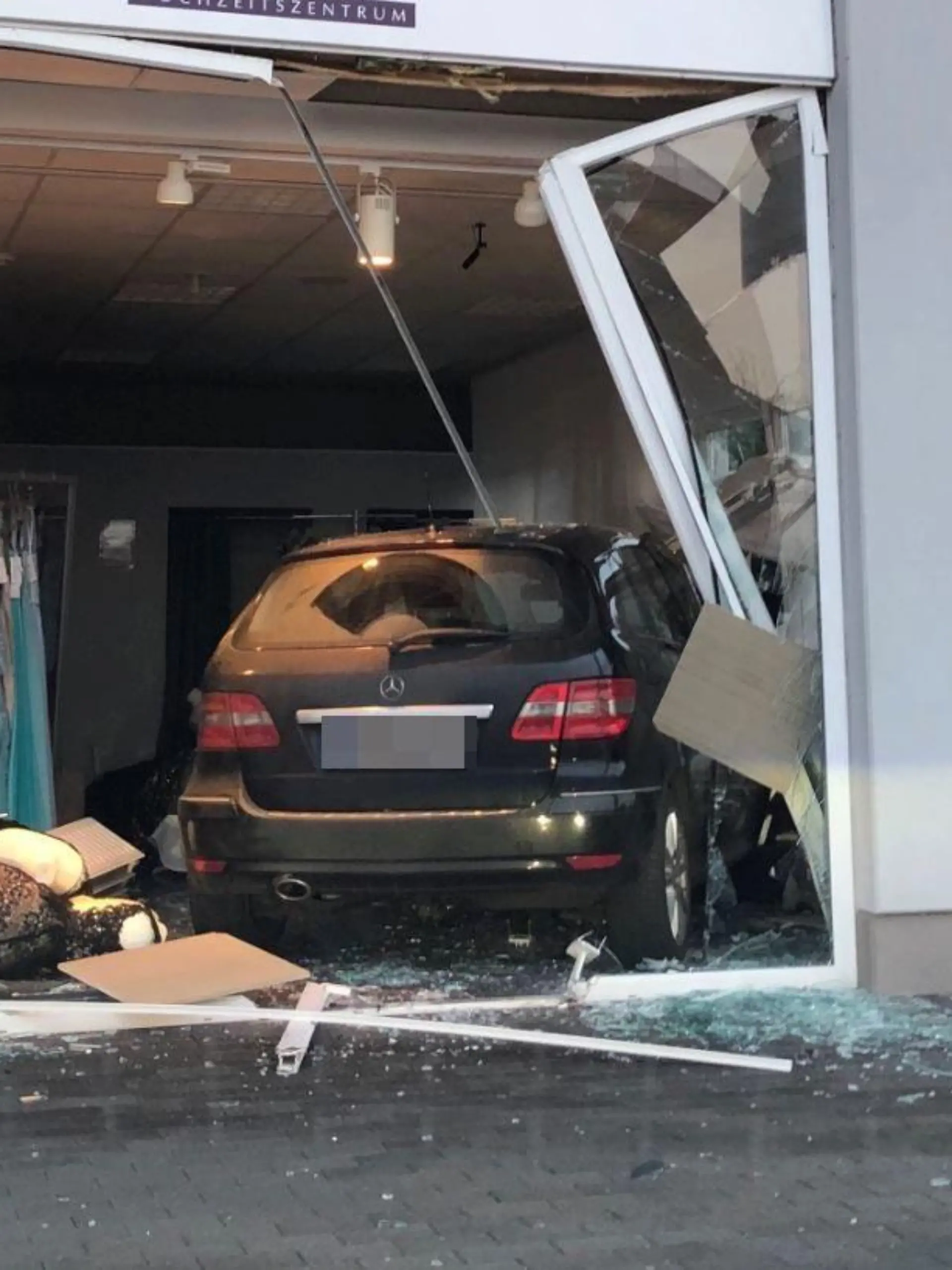 HANDOUT - 27.01.2022, Kerpen: Nach einem missglückten Einparkmanöver ist ein Auto in Kerpen erst im Verkaufsraum eines Brautmodengeschäfts zum Stehen gekommen. Verletzt wurde niemand. (Zu dpa: «Eingeparkt im Brautmodengeschäft») Foto: Polizei Hürth/Polizei/dpa - ACHTUNG: Nur zur redaktionellen Verwendung im Zusammenhang mit der aktuellen Berichterstattung und nur mit vollständiger Nennung des vorstehenden Credits. Das Kennzeichen wurde von der Polizei gepixelt. +++ dpa-Bildfunk +++