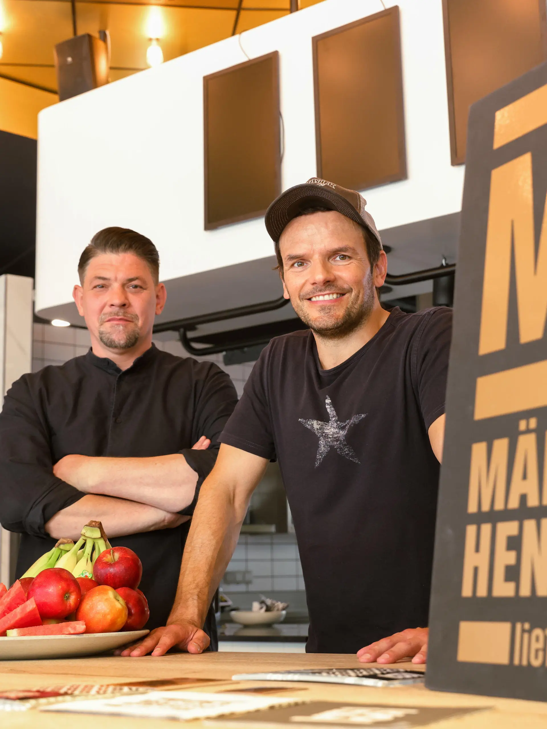PRODUKTION - 30.07.2021, Hamburg: Die Hamburger Köche Tim Mälzer (l) und Steffen Henssler stellen ihre neue Kochshow "Mälzer und Henssler liefern ab!" vor, die im Herbst bei Vox ausgestrahlt werden soll. Damit erhalten die Spitzenköche ihre erste gemeinsame Primetime-Show, in der sie im direkten Duell in ihrem gemeinsamen Pop-Up-Lieferservice gegeneinander antreten. (zu dpa «Mälzer und Henssler liefern ab!» - Verbal und kulinarisch) Foto: Ulrich Perrey/dpa +++ dpa-Bildfunk +++