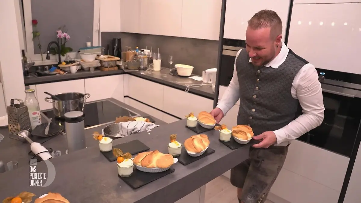 Mario balanciert zwei Schiefertafeln mit Salzburger Nockerln vom Küchentresen.