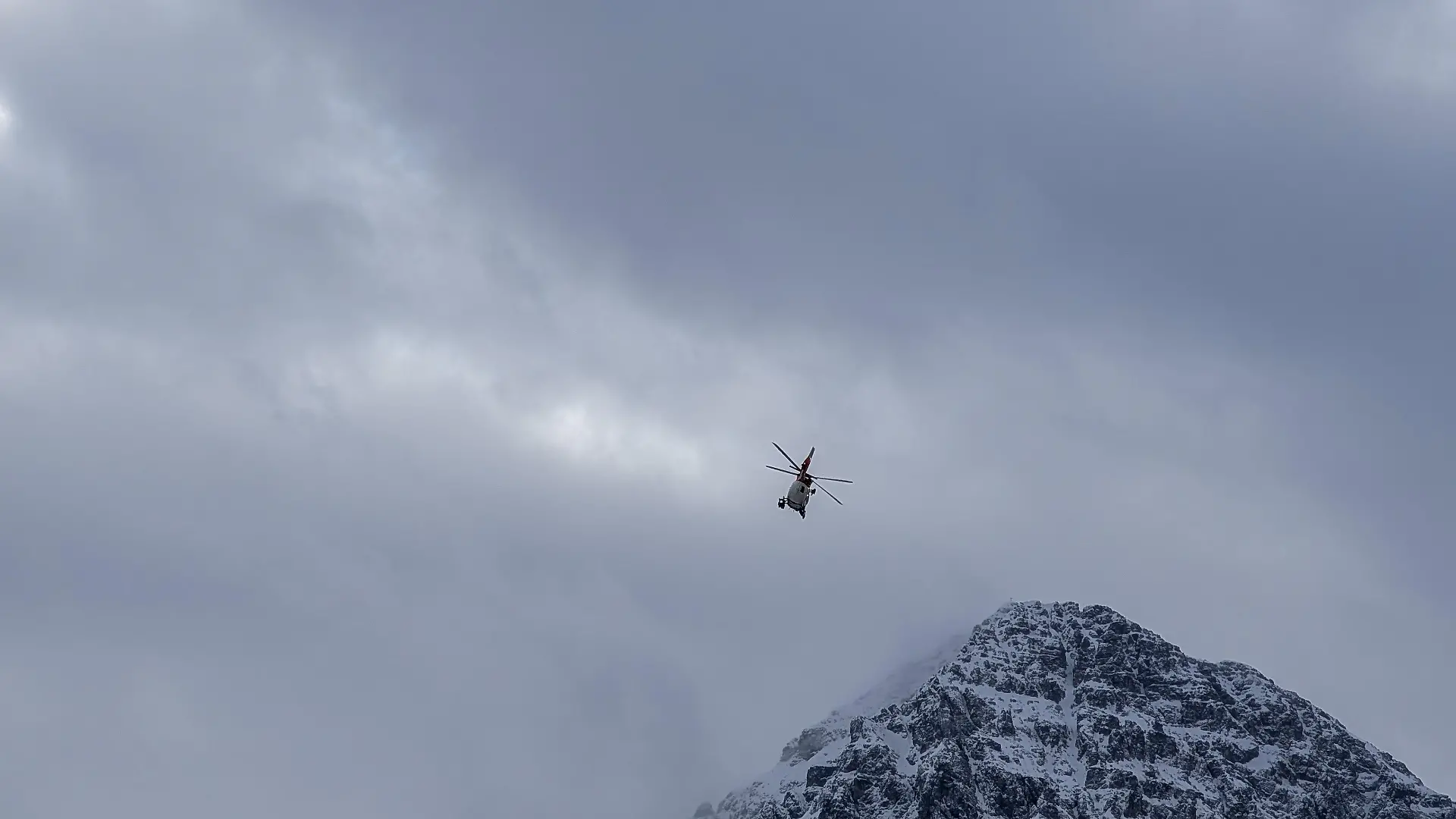 A mountain emergency rescue helicopter flies over a snow-covered mountain peak in Reutte, Tyrol, Austria, on January 3, 2026. The state-of-the-art red and white aircraft is utilized for challenging search and rescue missions in the alpine terrain of the greater Reutte area. (Photo by Michael Nguyen/NurPhoto)