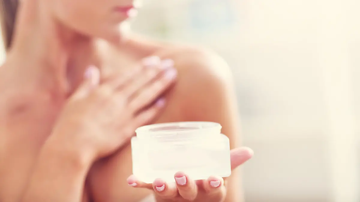 Picture showing fit woman holding lotion over her body