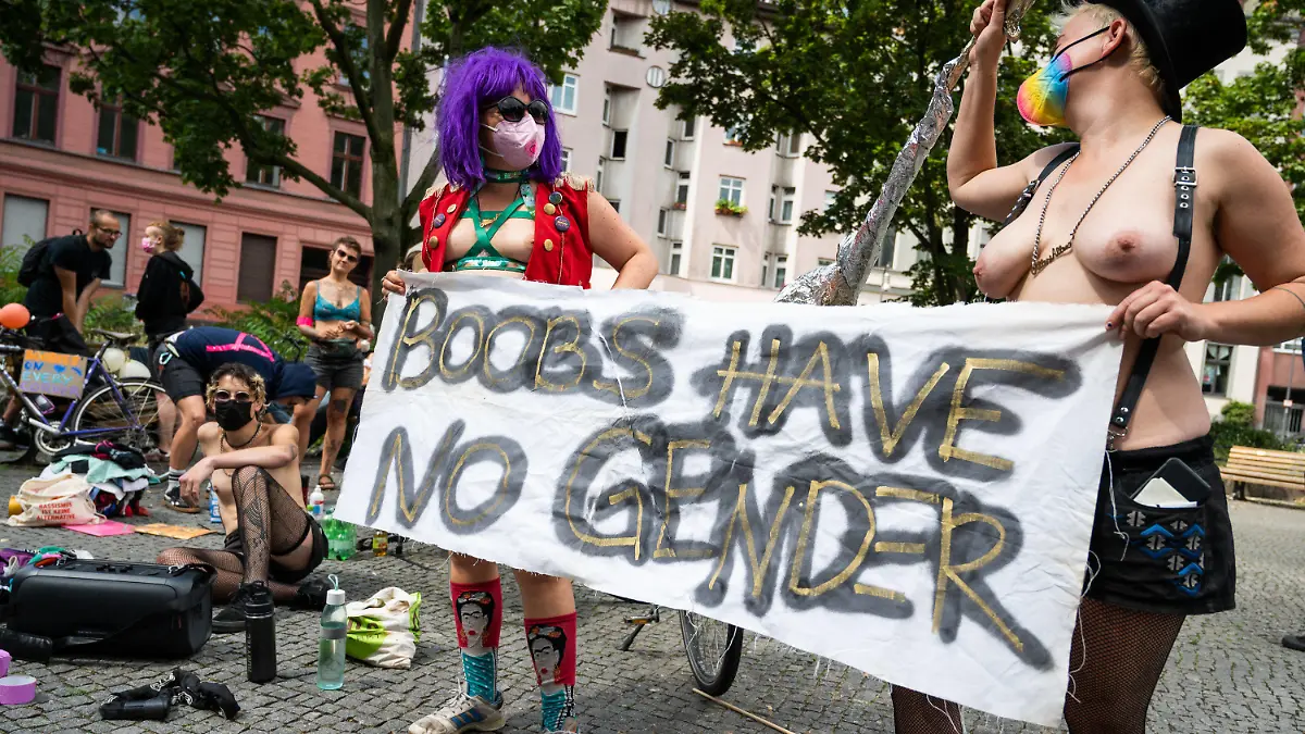 10.07.2021, Berlin: Teilnehmer einer Fahrraddemo unter dem Motto «No Nipple is free until all Nipples are free!» tragen ein Transparent mit der Aufschrift boobs have no gender. Die Demonstration ist eine Reaktion auf einen Polizeieinsatz bei dem sich eine Frau auf einem Spielplatz in Plänterwald mit nackter Brust sonnte. Foto: Christophe Gateau/dpa +++ dpa-Bildfunk +++
