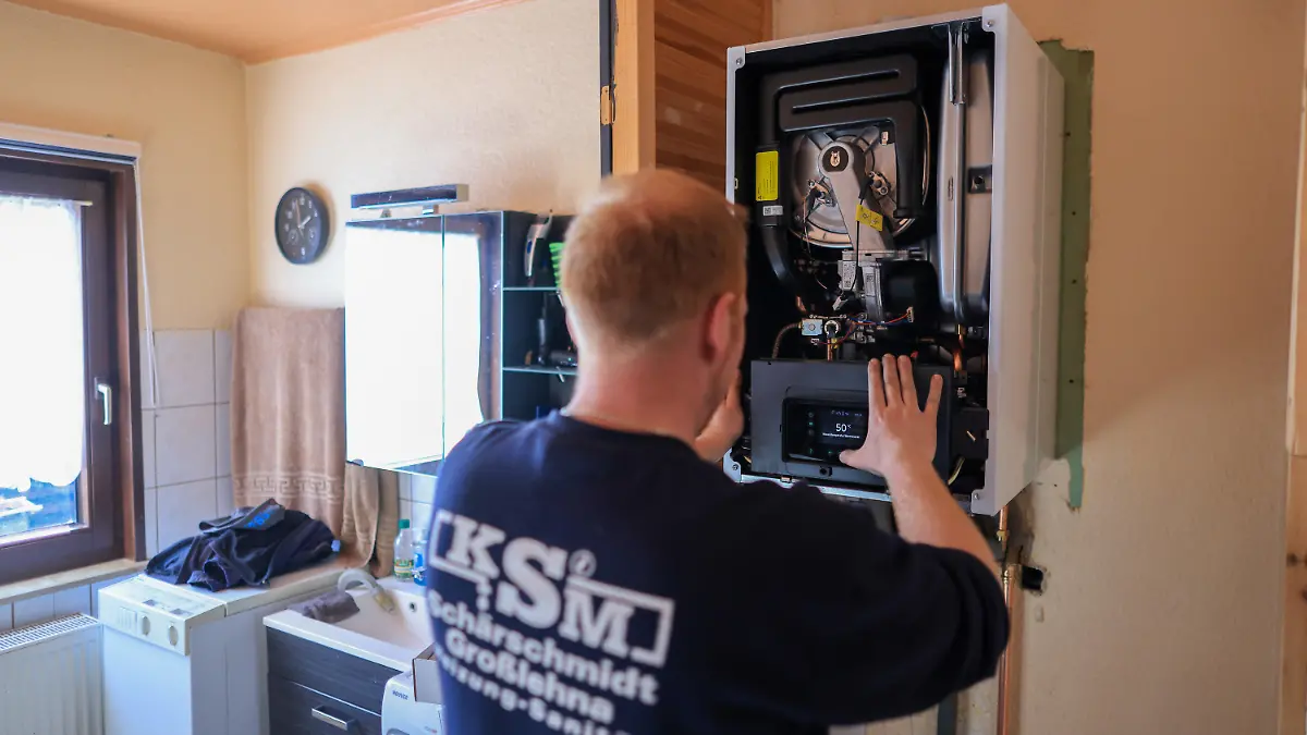 01.03.2023, Sachsen, Markranstädt: Ein Mitarbeiter einer Sanitär- und Heizungsbaufirma installiert eine moderne Gasbrennwerttherme in einem Einfamilienhaus. Die Pläne der Ampel-Koalition für die Heizungsumstellung auf erneuerbare Energien nehmen Gestalt an. Ab 2024 sollen keine neuen Erdgas- und Ölheizungen mehr eingebaut werden. An ihre Stelle träten Heizungen, die mindestens zu 65 Prozent mit erneuerbaren Energien betrieben werden. Derzeit heizt jeder zweite Haushalt in Deutschland mit Erdgas. Von der FDP kommt scharfe Kritik - und das Handwerk warnt, sich auf Technologien festzulegen. Foto: Jan Woitas/dpa +++ dpa-Bildfunk +++