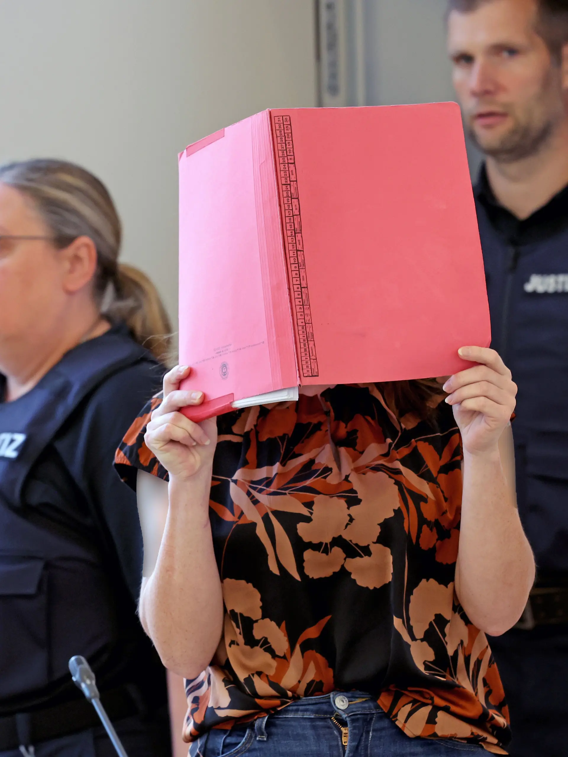 12.06.2026, Mecklenburg-Vorpommern, Rostock: Die Angeklagte wird in den Saal des Landgerichts geführt vor der Fortsetzung des Mordprozesses im Fall Fabian. Der Angeklagten wird vorgeworfen, am 10.10.2025 heimtückisch und aus sonst niedrigen Beweggründen den zur Tatzeit achtjährigen Fabian aus Güstrow getötet zu haben.