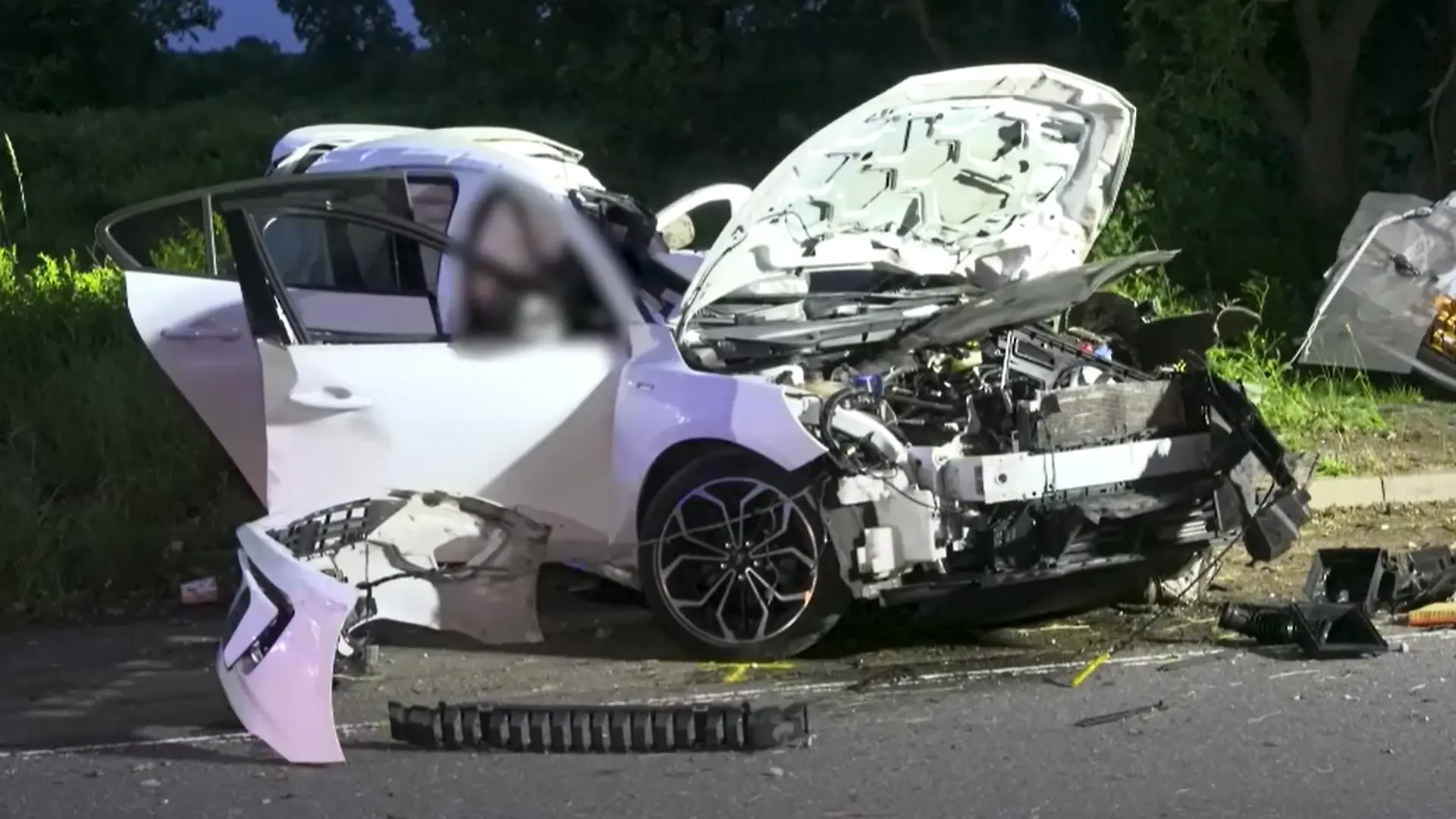 Einsatzkräfte bergen die beiden Insassen aus dem stark deformierten Fahrzeugwrack.